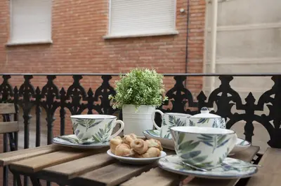a wooden table with cups and plates of food on it at Quart Apartment in Valencia