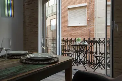 a dining table with a view of a balcony at Quart Apartment in Valencia
