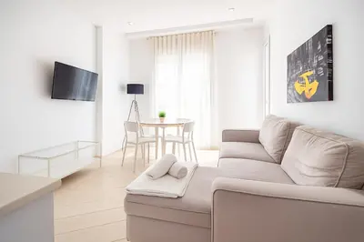 a white living room with a couch and a table at Tu Apartamento En El Centro-Ruzafa 9D in Valencia