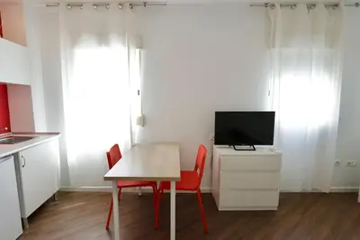 a bedroom with a bed and a desk and a television at Tu Estudio En El Centro-Ruzafa 10A in Valencia