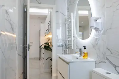 a white bathroom with a sink and a mirror at Top Floor 2 Bedroom Apartment with Terrace in Valencia