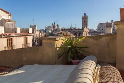 a view of a city from a balcony with a plant at Ático Exclusivo del Siglo XVI con Dos Terrazas en el Corazón de Ciutat Vella in Valencia