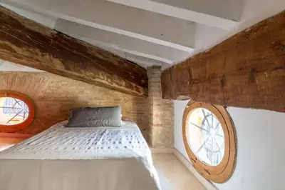 a bedroom with a bed and a large window at Ático Exclusivo del Siglo XVI con Dos Terrazas en el Corazón de Ciutat Vella in Valencia