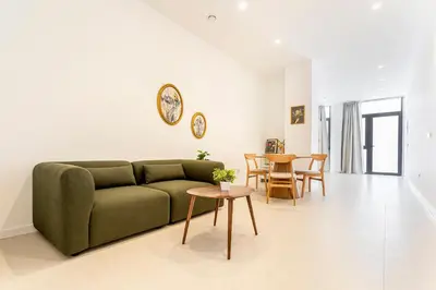 a living room with a green couch and a table at C - Design apartment El Grao close to the beach in Valencia