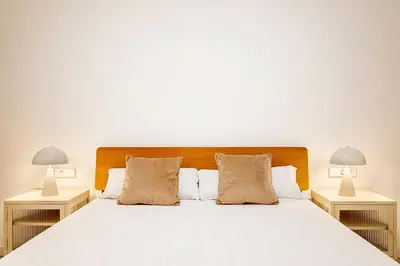 a bedroom with a white bed with two lamps at C - Design apartment El Grao close to the beach in Valencia