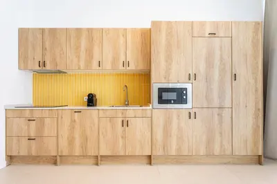 a kitchen with wooden cabinets with a sink and a microwave at C - Design apartment El Grao close to the beach in Valencia