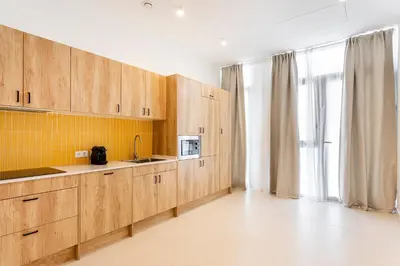 a kitchen with wooden cabinets and a microwave at C - Design apartment El Grao close to the beach in Valencia