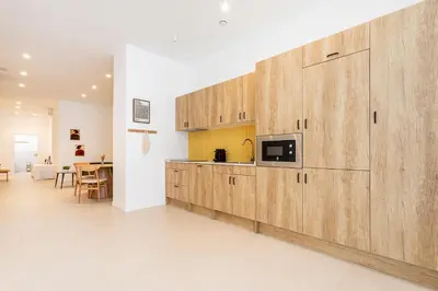a kitchen with wooden cabinets and a microwave at C - Design apartment El Grao close to the beach in Valencia