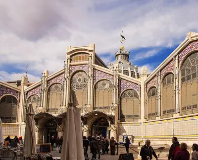 a large building with people walking in front of it at Ático Exclusivo del Siglo XVI con Terraza Privada en el Corazón de Ciutat Vella in Valencia