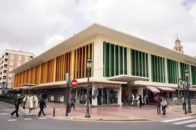 a large building with people walking in front of it at Ático Exclusivo del Siglo XVI con Terraza Privada en el Corazón de Ciutat Vella in Valencia