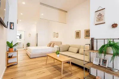 a living room with a couch and a bed at Hridaya El Grao close to the sea in Valencia