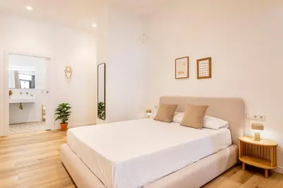 a white bedroom with a large white bed in it at Hridaya El Grao close to the sea in Valencia