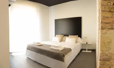 a bedroom with a white bed with towels on it at Soho Valencia in Valencia