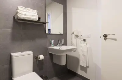 a bathroom with a white toilet and a sink at Soho Valencia in Valencia