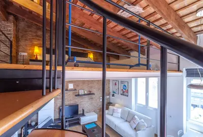 a loft with a couch and a tv in a room at Penthouse apartment historical center in Valencia