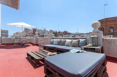 a patio with a couch and a table and an umbrella at Penthouse apartment historical center in Valencia