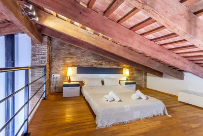 a bedroom with a large bed and a brick wall at Penthouse apartment historical center in Valencia
