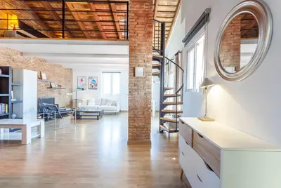 an exposed brick wall in a loft with a living room at Penthouse apartment historical center in Valencia