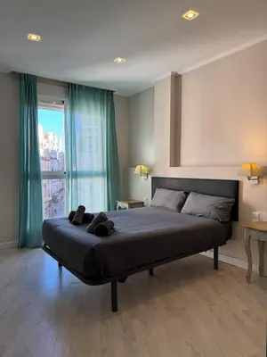 a bedroom with a large bed with a large window at Tu Apartamento En El Centro - Ruzafa 8D in Valencia