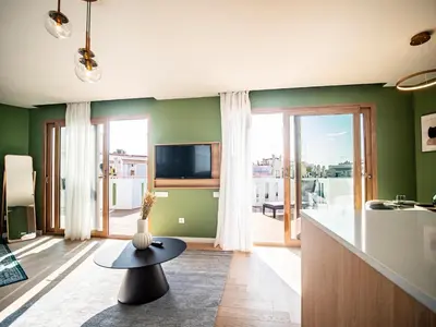 a living room with green walls and a table at Tu Penthouse En El Centro - Ruzafa 11C in Valencia