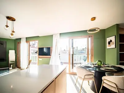 a kitchen with green walls and a table and chairs at Tu Penthouse En El Centro - Ruzafa 11C in Valencia