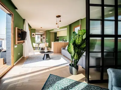 a living room with green walls and a couch at Tu Penthouse En El Centro - Ruzafa 11C in Valencia
