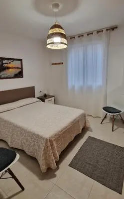a bedroom with a large bed and a chandelier at Mar y montaña in Nules