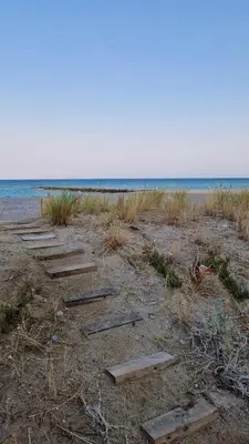 a wooden path on the beach with the ocean in the background at Mar y montaña in Nules