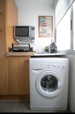 a kitchen with a washing machine and a microwave at Casa vistas al rio in Navajas