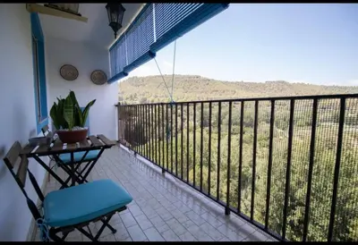 a balcony with a chair and a table with a view at Casa vistas al rio in Navajas