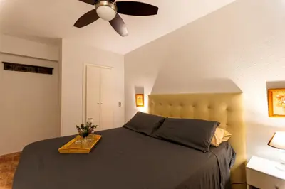 a bedroom with a bed with a ceiling fan at A pié de playa Rincón acogedor Amanecer in Cullera