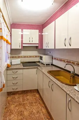 a kitchen with white cabinets and a sink at A pié de playa Rincón acogedor Amanecer in Cullera