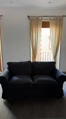 a black couch in a living room with a window at Plaza la REINA 3th floor & no elevator in Valencia