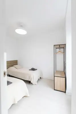 two beds in a white room with a mirror at Encantador Apartamento de Lujo en Valencia 3 Dormitorios in Paterna