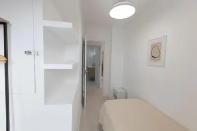 a white room with a bed and a hallway at Encantador Apartamento de Lujo en Valencia 3 Dormitorios in Paterna