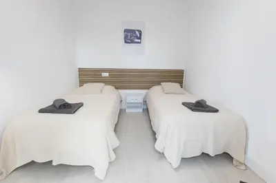 two beds in a room with white walls at Encantador Apartamento de Lujo en Valencia 3 Dormitorios in Paterna