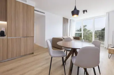 a kitchen and living room with a table and chairs at ApartUP Port Marina Azura in Valencia