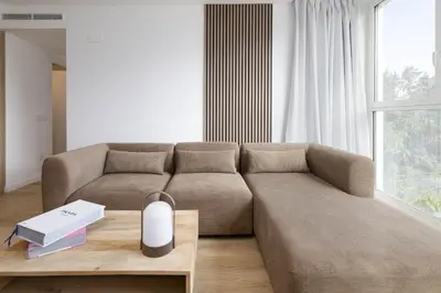 a living room with a brown couch and a table at ApartUP Port Marina Azura in Valencia