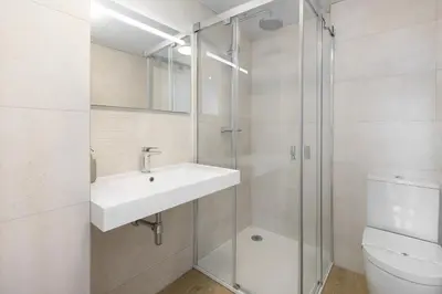 a bathroom with a sink and a glass shower at ApartUP Port Marina Azura in Valencia