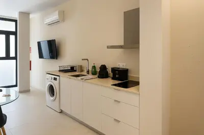 a kitchen with a washer and dryer on a counter at Roca Collection MSuites in Valencia