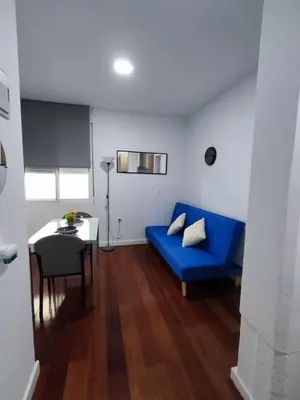 a living room with a blue couch and a table at Benimaclet JTM in Valencia
