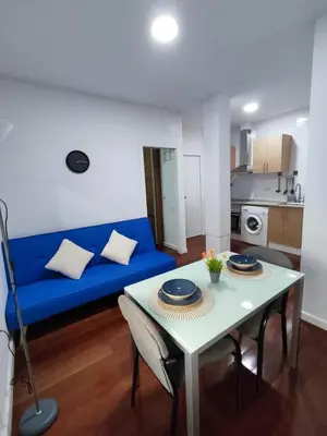 a living room with a blue couch and a table at Benimaclet JTM in Valencia
