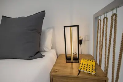 a mirror on a wooden table next to a bed at Estudio con Altillo en Malilla cerca de La Fe in Valencia