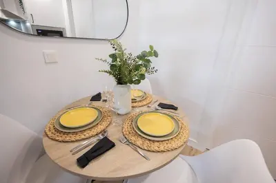 a table with two yellow plates and a mirror at Estudio con Altillo en Malilla cerca de La Fe in Valencia