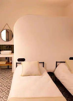 a bedroom with two beds and a mirror at Casa Abadía Alojamiento completo boutique cerca de Valencia in Alfarp