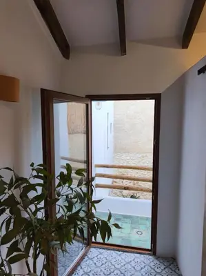 a plant in a room with a large window at Casa Abadía Alojamiento completo boutique cerca de Valencia in Alfarp