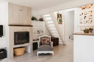 a living room with a fireplace and a chair at Brisas Chulilla Loft with Terrace in Chulilla