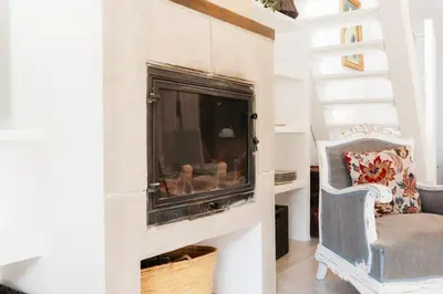 a living room with a fireplace and a chair at Brisas Chulilla Loft with Terrace in Chulilla