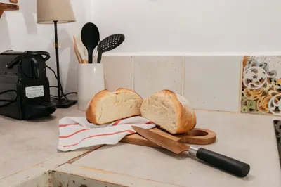a loaf of bread on a cutting board with a knife at Brisas Chulilla Boutique Apartment in Chulilla