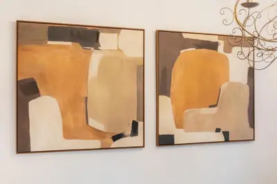 two framed paintings of chairs on a wall at Brisas Chulilla Boutique Apartment in Chulilla